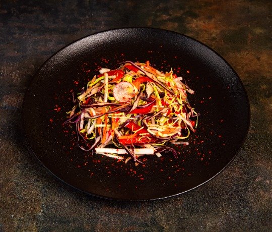 Fresh vegan Indian dishes delivered by Thindian Dark plate with a mixed salad with peppers, cabbage and radish